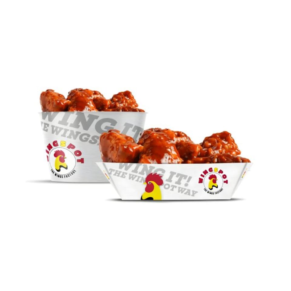 Two containers of WINGSPOT chicken wings, one bucket and one boat, filled with saucy red wings.