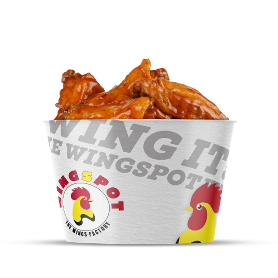 WINGSPOT bucket filled with saucy chicken wings, against a white background.