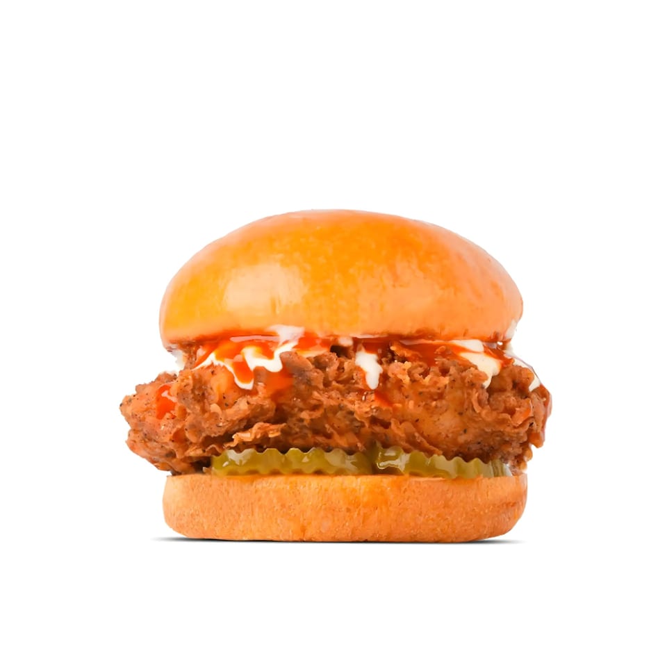 WINGSPOT's crispy chicken sandwich with sauce and pickles on a brioche bun.